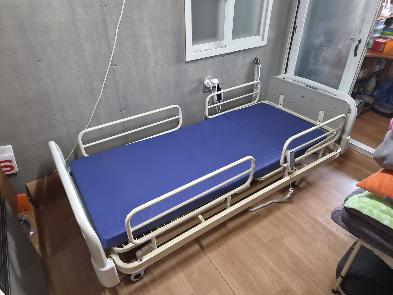 충북 전동침대대여 안내용 참고사진 - 창가 방에 설치된 파란 매트리스 전동침대